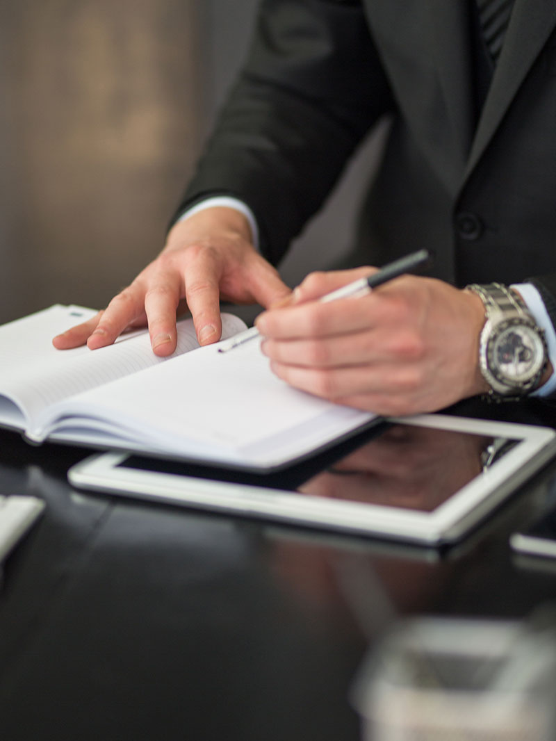 Suited male signing documents